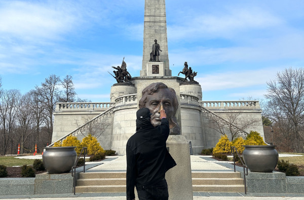 Sherman "Dilla" Thomas rubs the brass bust of Abraham Lincoln at his tomb in Springfield