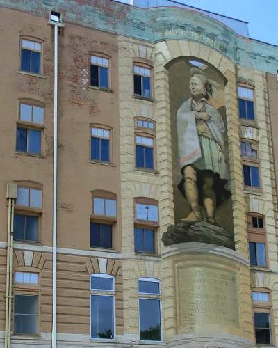 A large three-storey high mural of Blackhawk on the frontage of a brick building